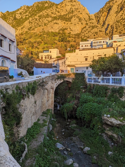       Stone bridge and water with colorful buildings in the background.
  