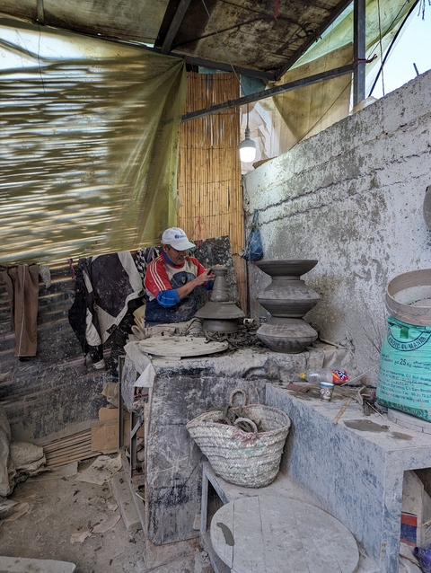       Man working with clay in a pottery workshop.
  