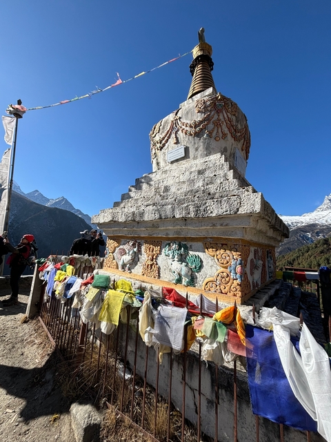       Chorten with prayer flags and mountain backdrop.
  