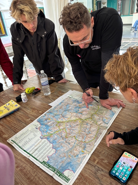       Map on a table with people pointing at it.
  