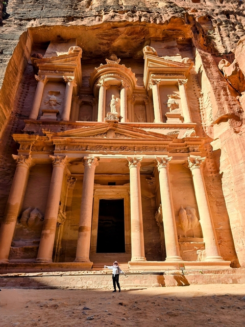 The Petra Treasury lit by sunlight under a clear sky