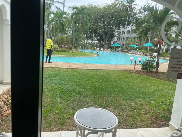 A pool view from a window with a person nearby.