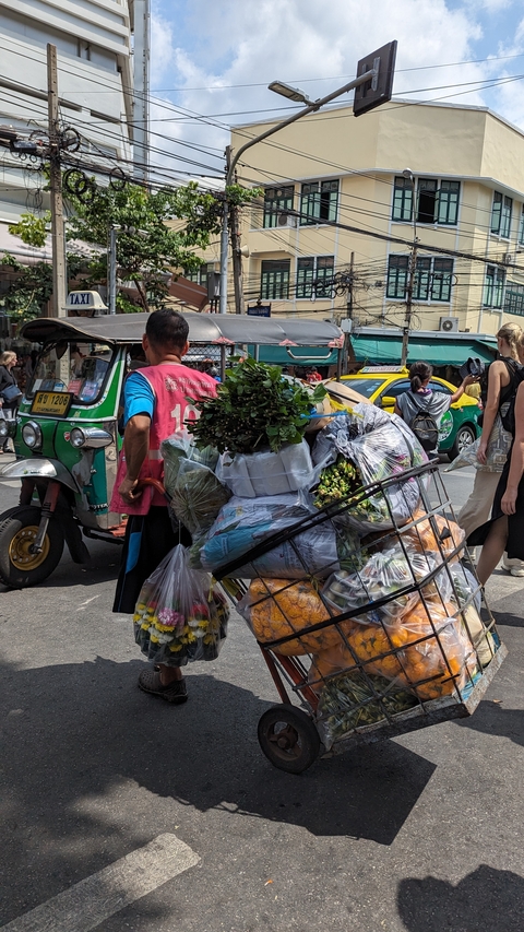 Street vendor with a large cart in a market area.