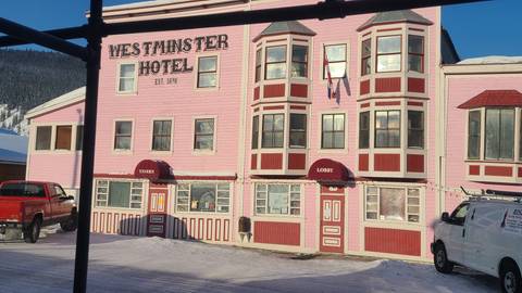 A pink historical hotel building in a snowy setting.