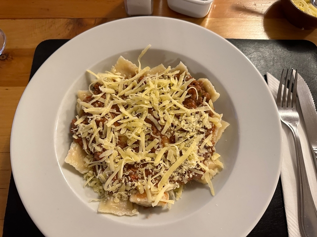       Plate of pasta topped with grated cheese.
  