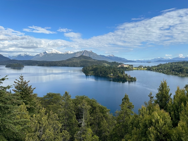       Beautiful view of a lake surrounded by forest and mountains.
  