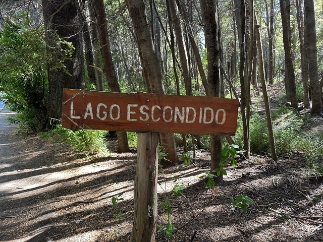       Wooden sign pointing towards Lago Escondido.
  