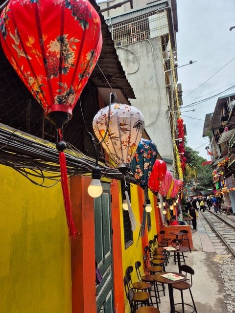       Street with colorful lanterns and pedestrian activity.
  