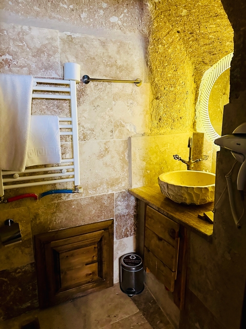       Bathroom with stone sink and towel rack.
  