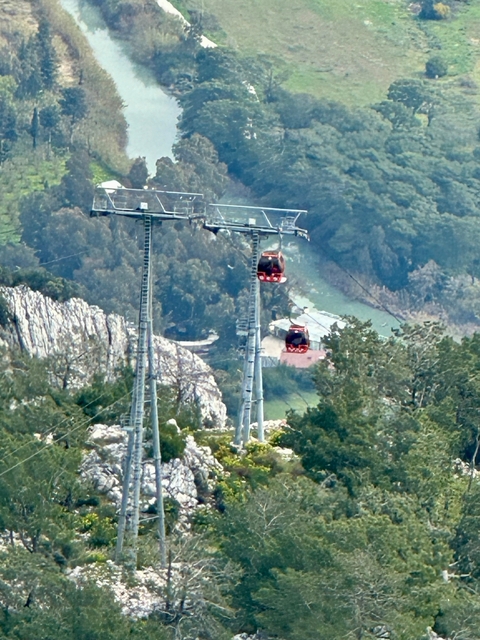       Cable cars moving on a mountain landscape.
  