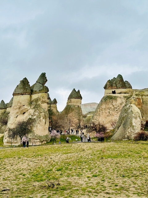       People walking among fairy chimney formations.
  
