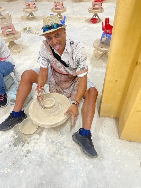 Person shaping clay on a potter's wheel.