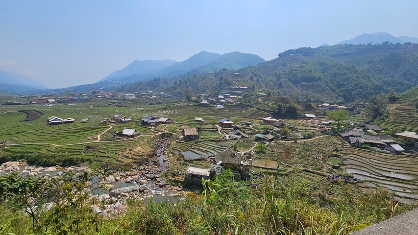 Terraced rice fields in a valley surrounded by hills.