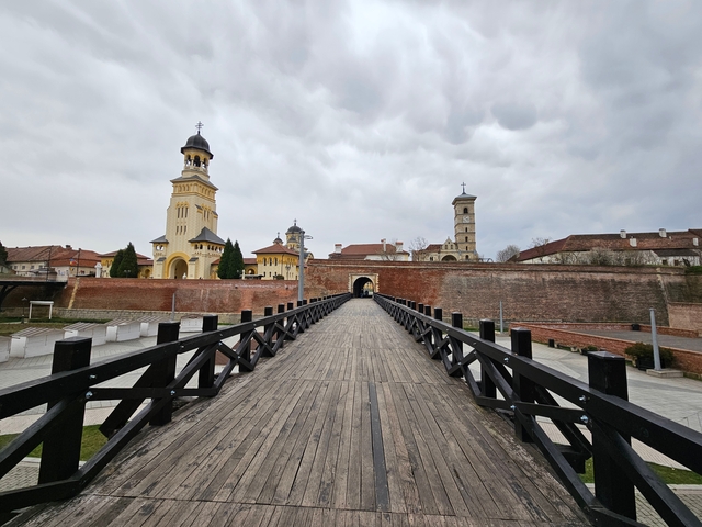       Historic fortress with a wooden bridge entrance, surrounded by stone walls.
  