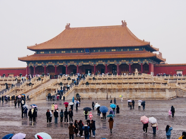       Crowds with umbrellas at the Forbidden City on a rainy day.
  