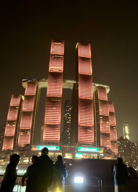 Modern skyscrapers illuminated at night with intricate architectural design.