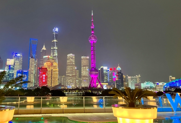       Shanghai skyline lit up at night, with the Oriental Pearl Tower prominently visible.
  