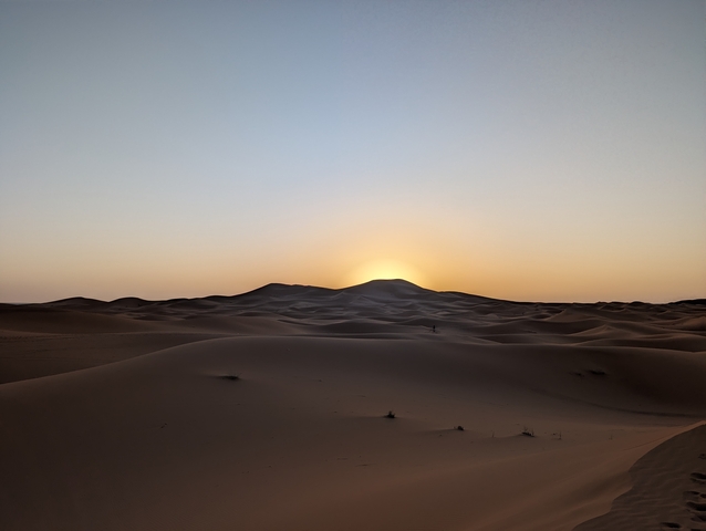 Distant horizon over sand dunes at sunset.