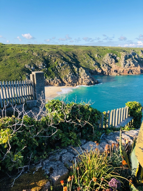 Cliffside view of a beach with turquoise water.