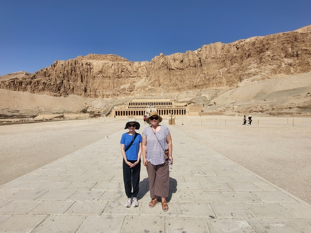 Two people posing in front of an ancient temple.