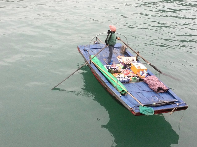       A small boat filled with goods on a body of water.
  