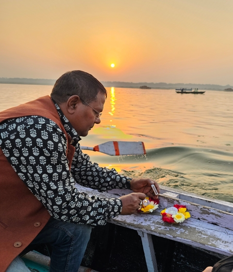       Man on a boat at sunset on a river.
  