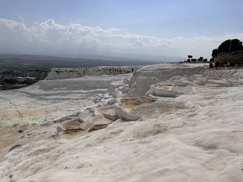       The travertine terraces of Pamukkale with a clear sky.
  