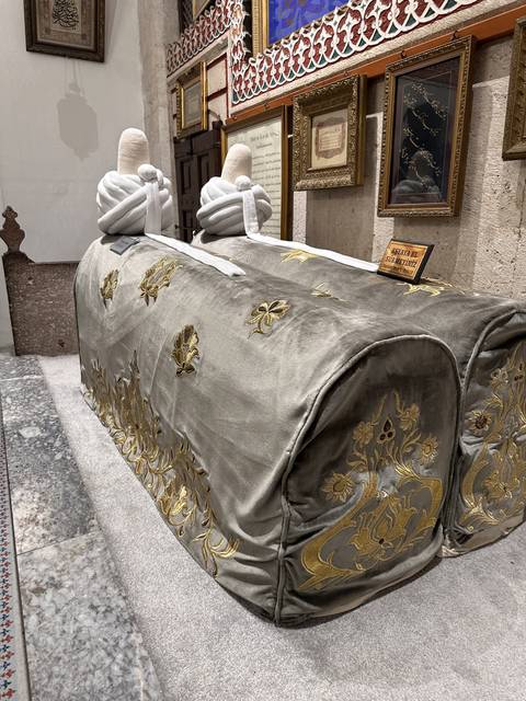 Traditional tomb in a museum setting with ornate designs.