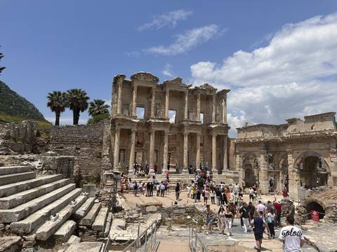       A historic building with tourists exploring its surroundings.
  
