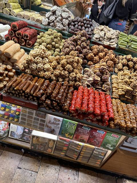       A colorful display of dried fruits and sweets in a market.
  