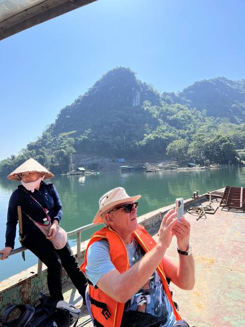       A person taking a photo while on a boat trip
  
