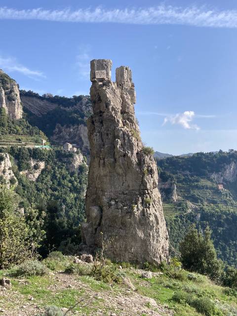       Rocky cliff formation under a clear sky.
  