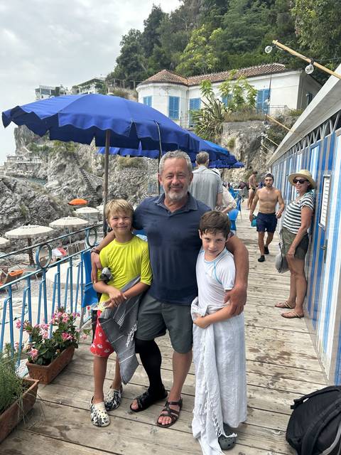       Family posing together at a coastal restaurant.
  