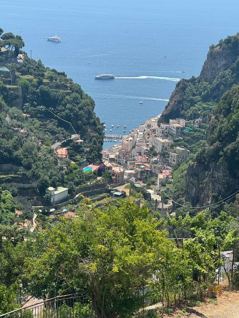       Cliffside view of a town with the sea in the background.
  