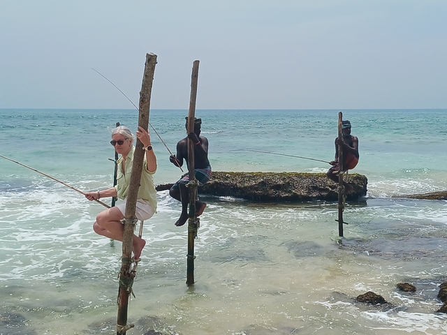 People fishing on stilts by the sea.