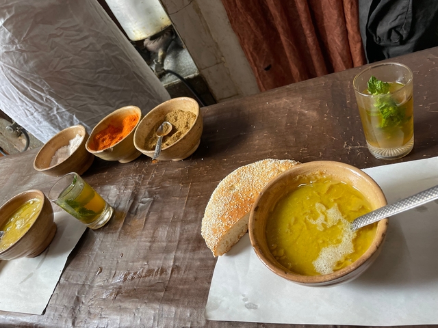       Traditional Moroccan meal with spices and tea on a table.
  