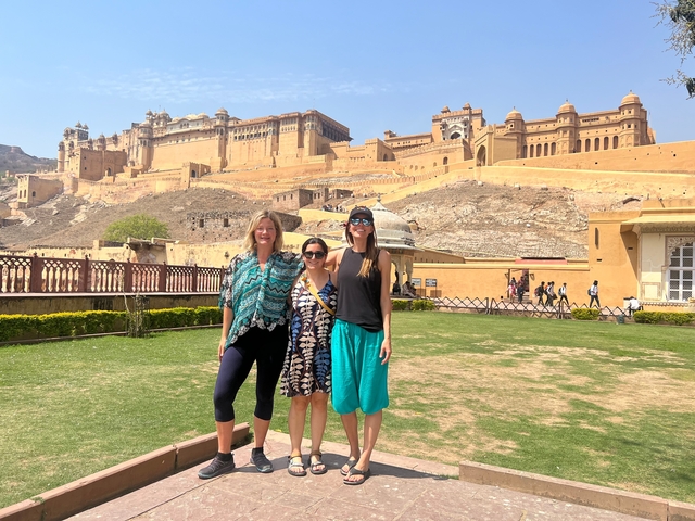       Three people posing in front of Amber Fort.
  