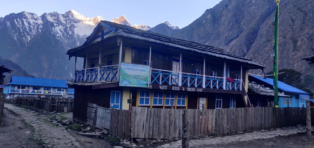       Guest house against a backdrop of snowy mountains.
  