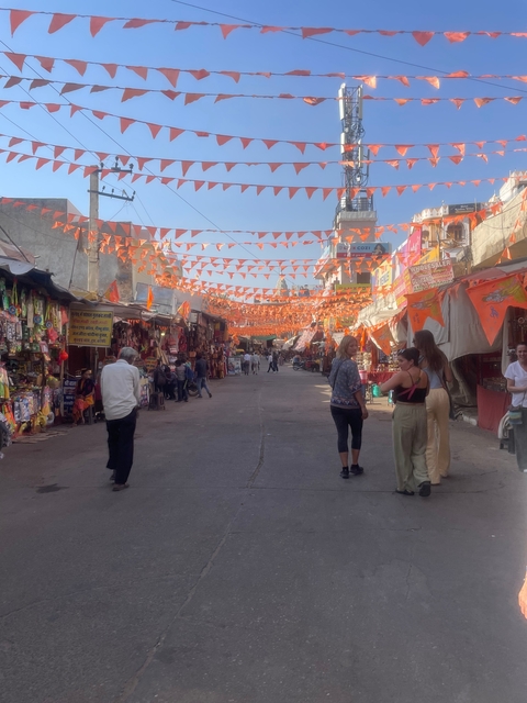       Market street with people and colorful flags.
  