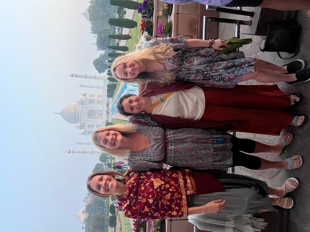       Group of people posing in front of Taj Mahal.
  
