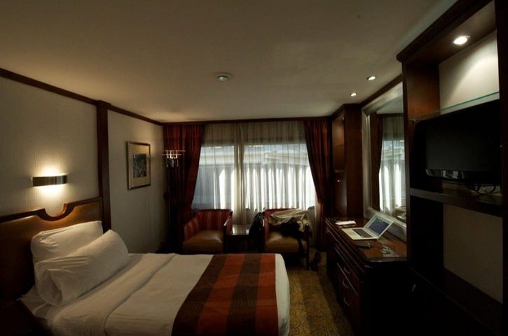 A cozy hotel room with drawn curtains and ambient lighting.