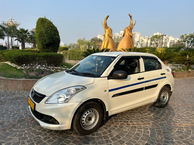 A white hatchback car parked in a garden area.