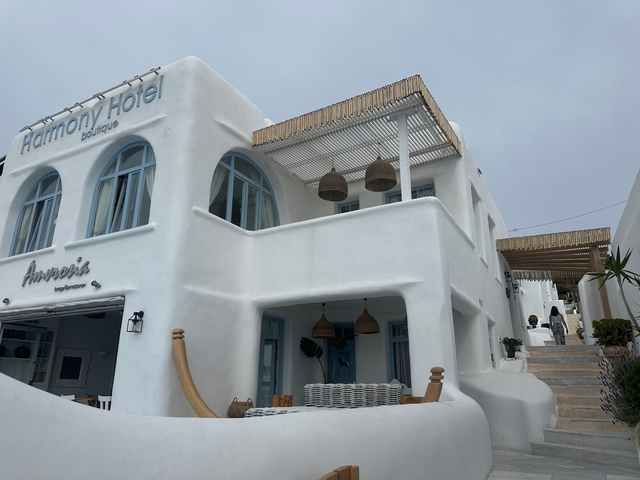       White Mediterranean-style building with blue windows.
  