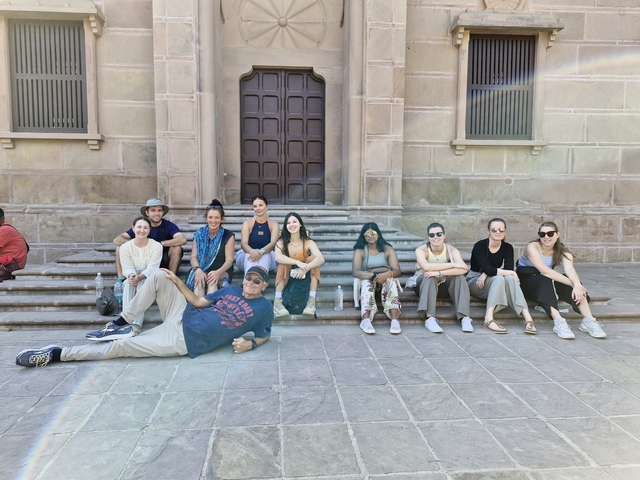       Group of people sitting on steps in front of a building.
  