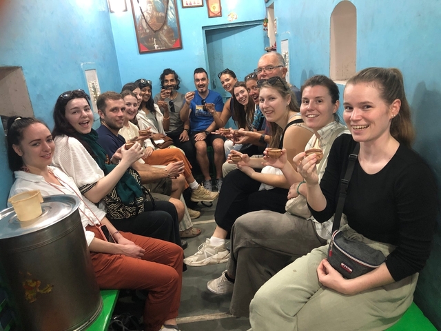       Group of people sitting in a small room enjoying drinks.
  