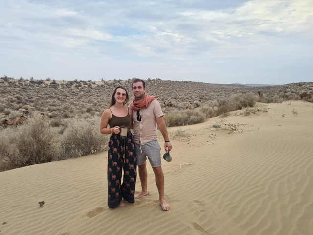       Couple standing in a desert landscape.
  