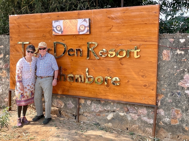       A couple posing in front of a resort sign in Ranthambore.
  
