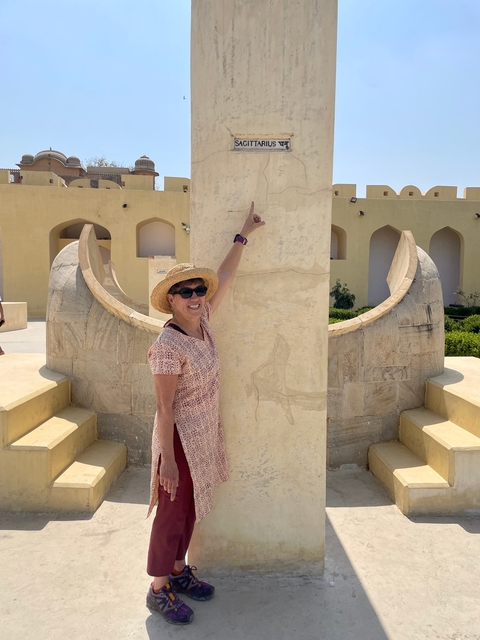 Woman pointing at a sun clock structure.