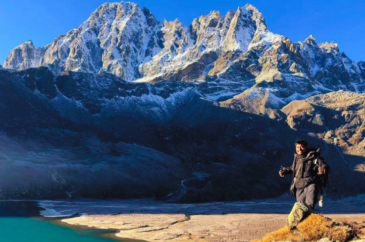 Person in winter clothing with a mountainous backdrop.