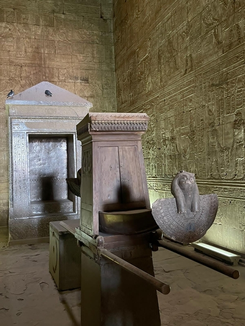Ancient Egyptian stone throne and carved walls.